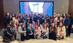 A large group of students in four rows, some sitting and others standing. They are at an awards ceremony and are smiling and happy.